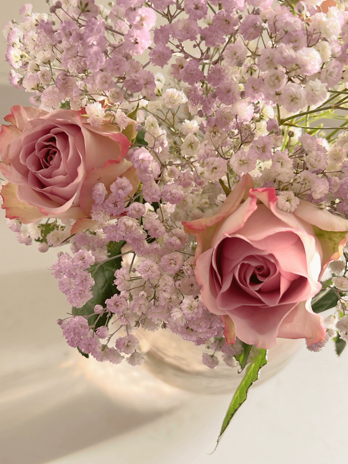 Close up photo of bouquet of purple roses and baby's breath on a white background. Fairy Bunch | FLOWERFIX